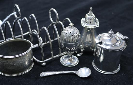 A group of small silver including two toastracks, a pepper pot, a napkin ring and two plated cruets.